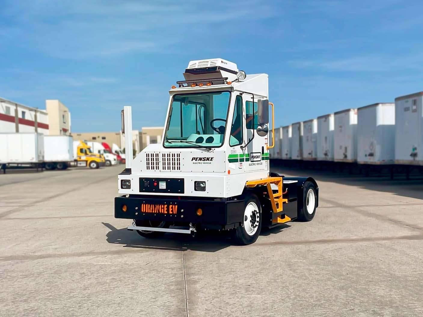 A Penske electric yard truck in a parking lot.