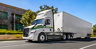 A white Penske semi truck driving down the road