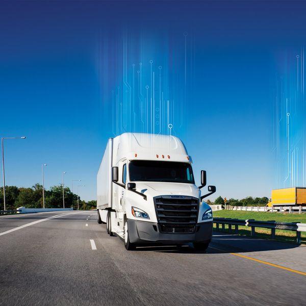 A white tractor truck drives up a freeway.