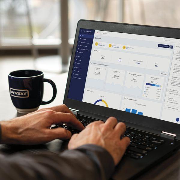Close-up of hand typing on a laptop, looking at the Fleet Insight app.