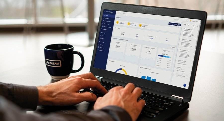 Close-up of hand typing on a laptop, looking at the Fleet Insight app.