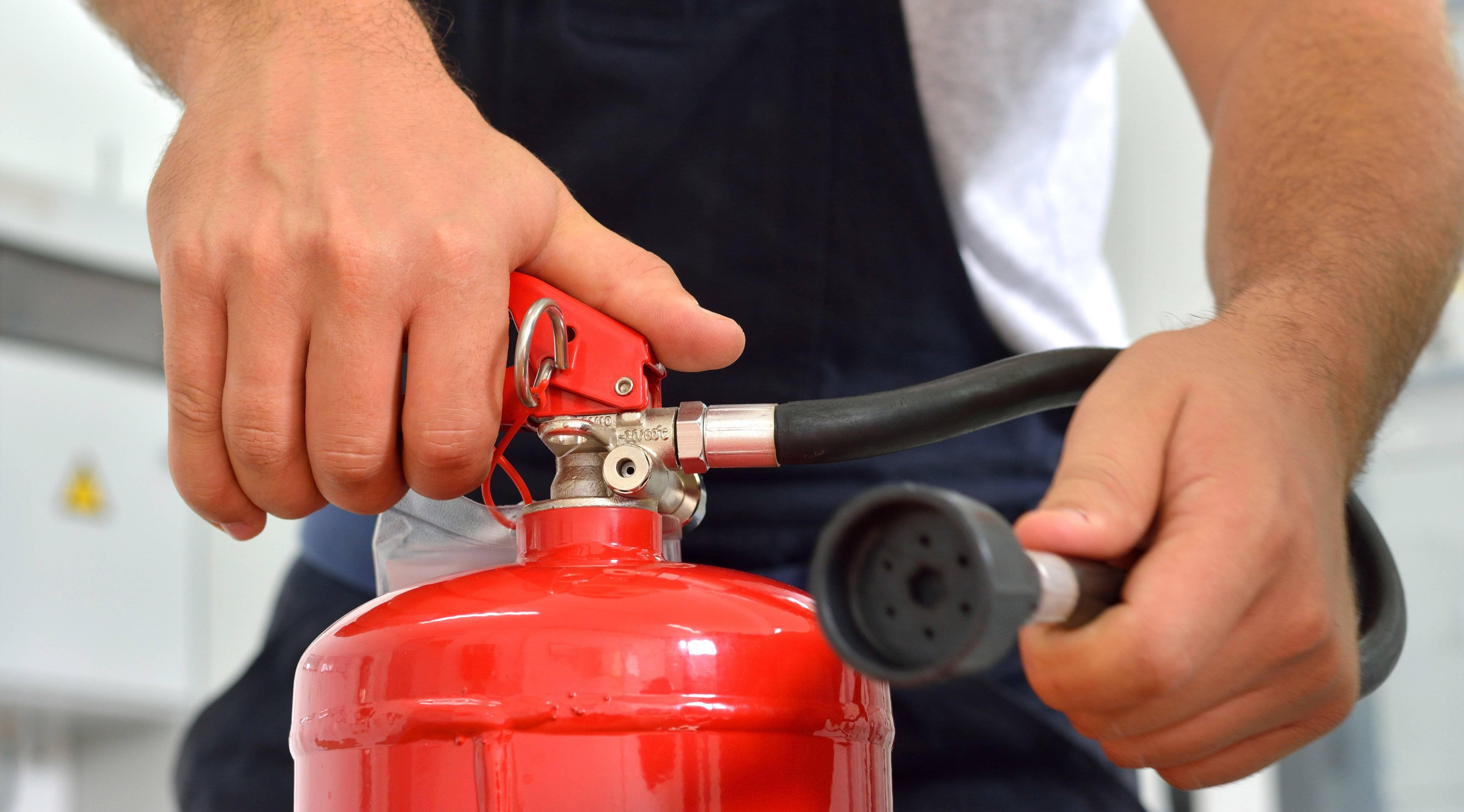 Truck driver holds a fire extinguisher.