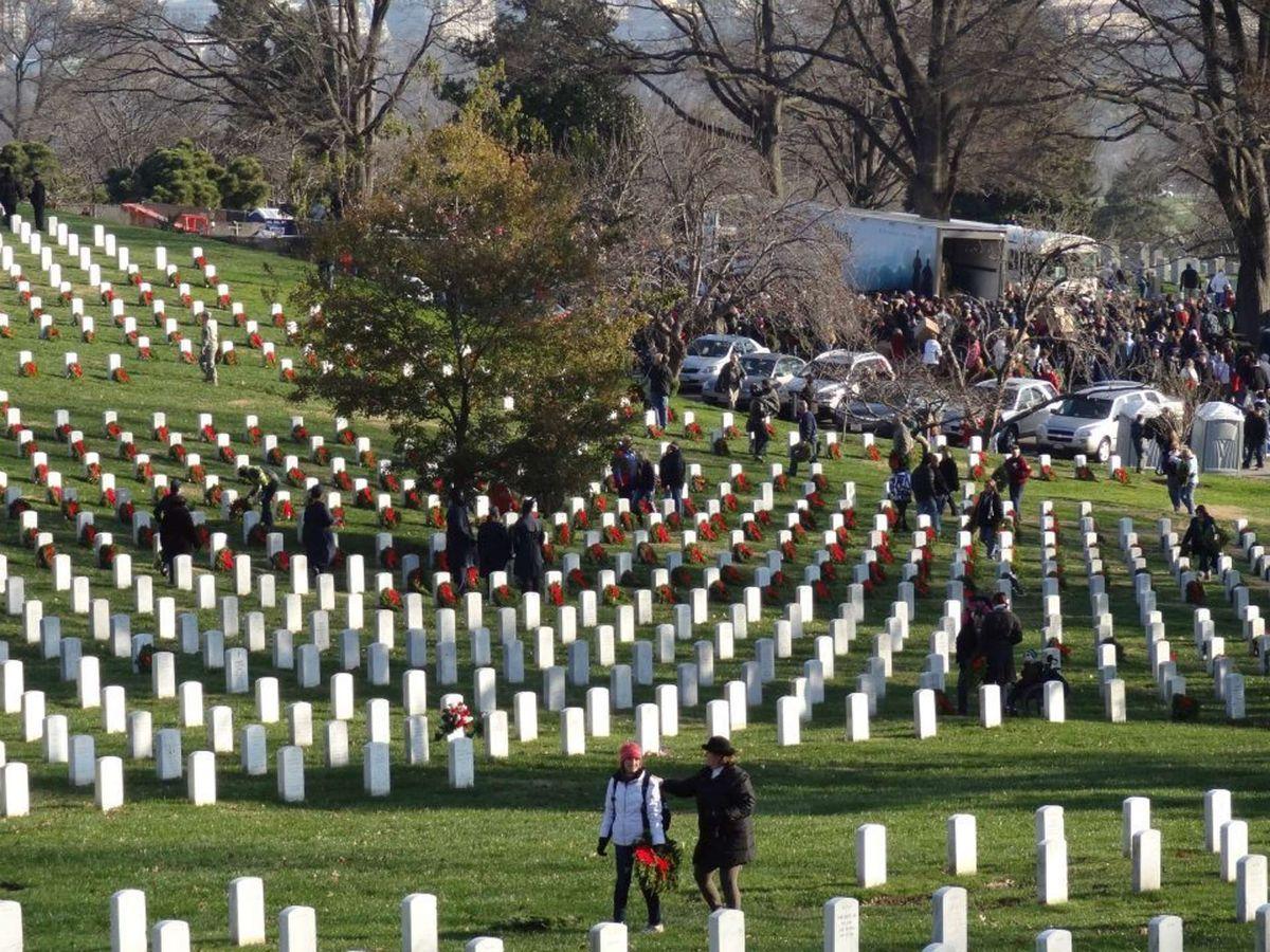Two people lay wreaths at Arlington National Cemetery